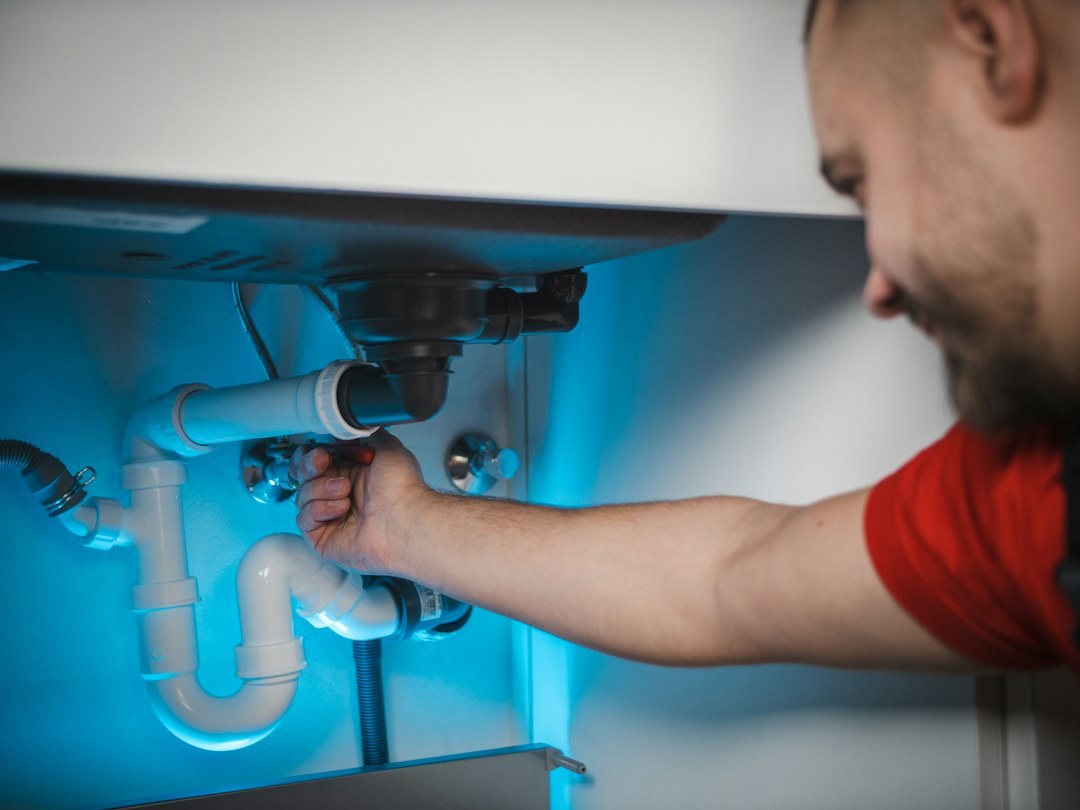 Person working on an exposed household pipe