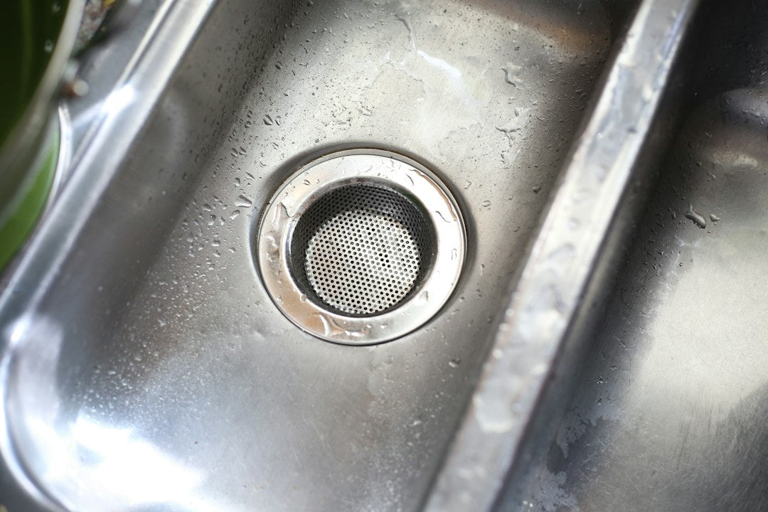 Stainless steel sink basin with a drain strainer
